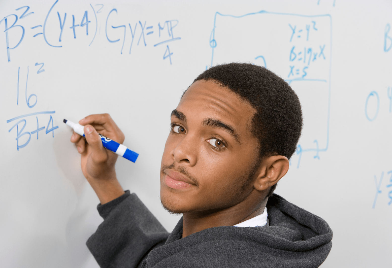 a student is writing on a whiteboard