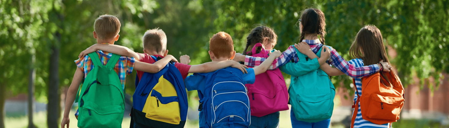 a group of children with backpacks walking down a path