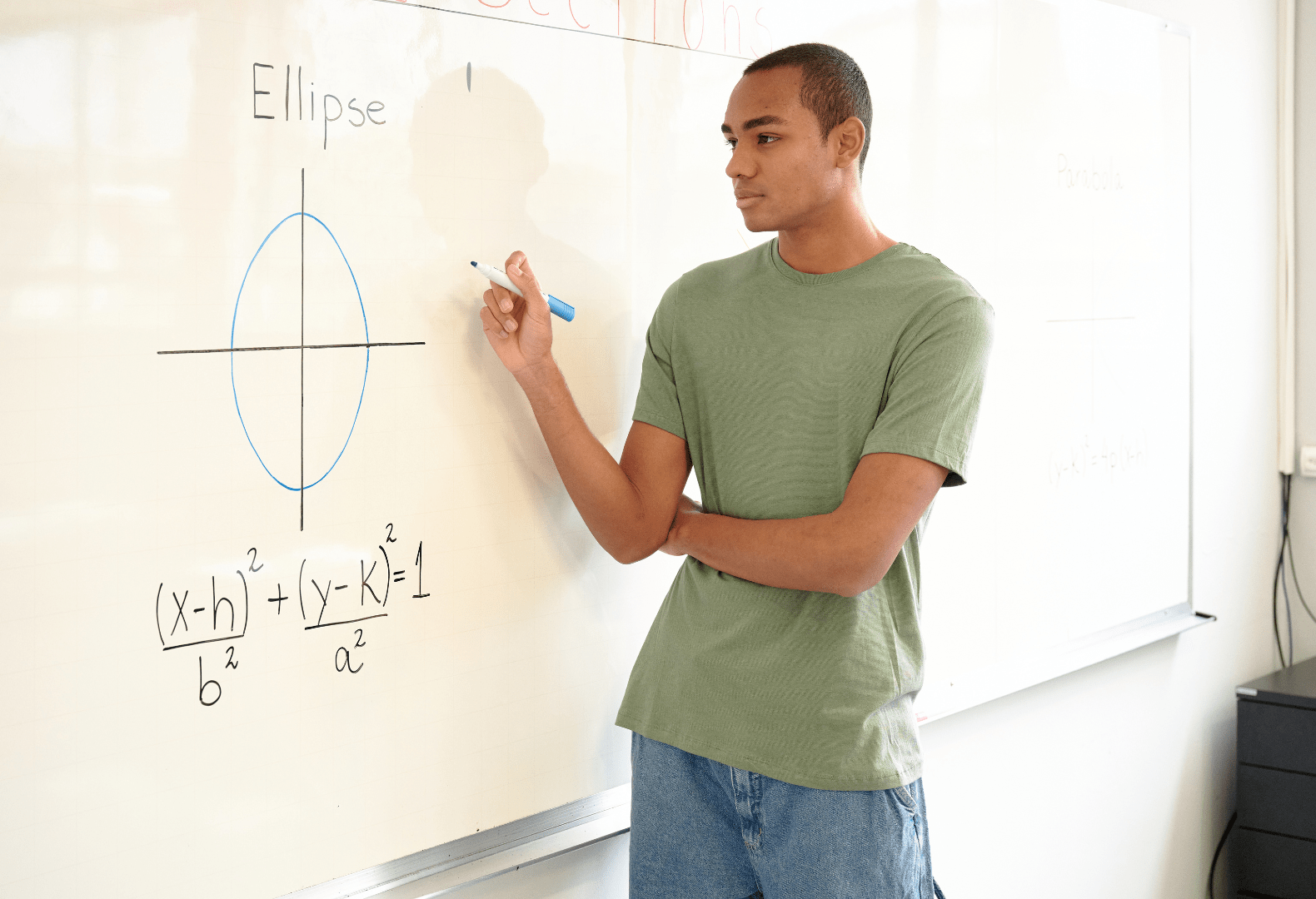 a student standing in front of a whiteboard writing on it