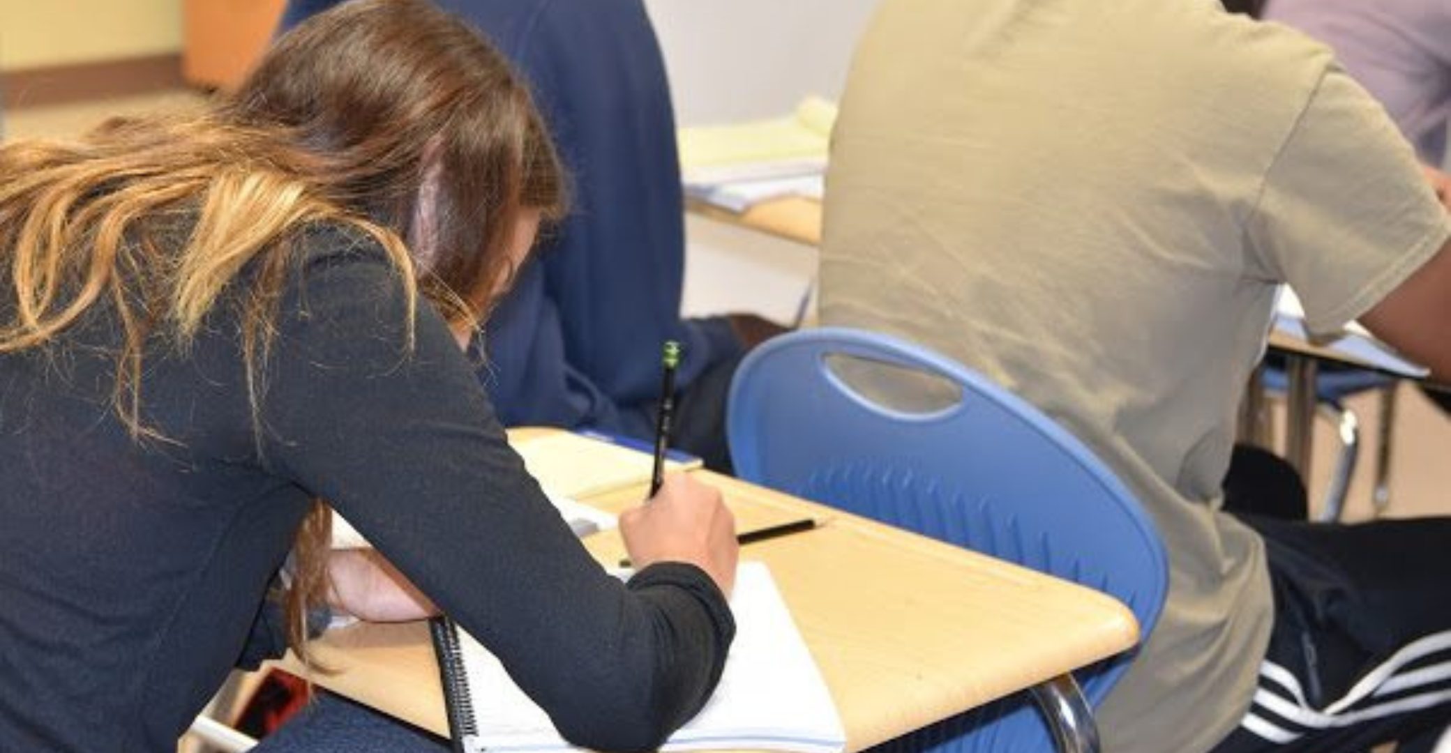 A female student writing on a desk